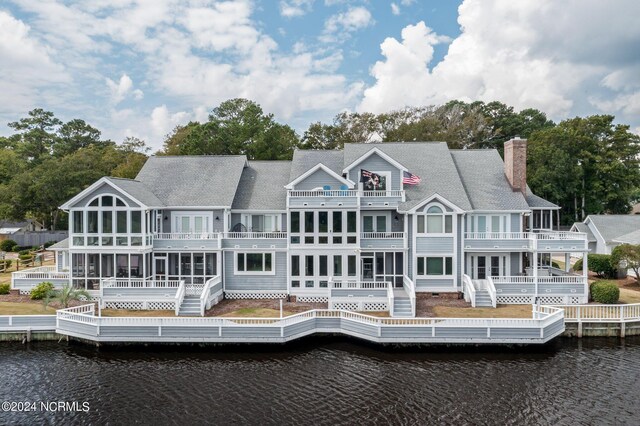 back of house featuring a balcony, a sunroom, and a deck with water view