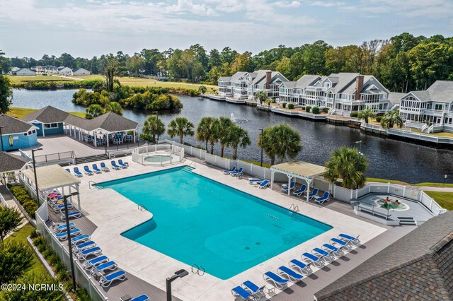 view of swimming pool with a patio and a water view