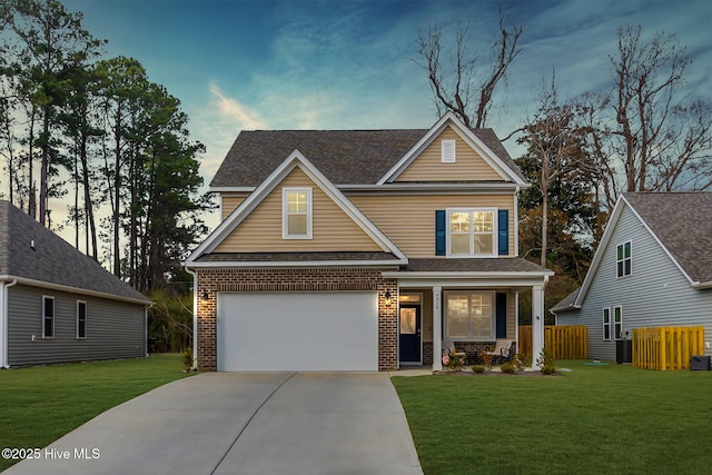 craftsman house with a garage, a yard, and central AC unit