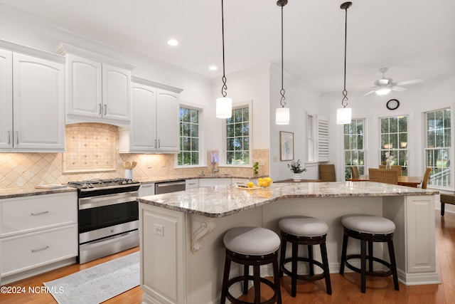 kitchen with a center island, light wood-type flooring, white cabinetry, and stainless steel appliances