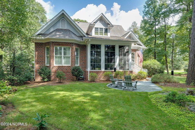 back of house featuring a sunroom and a lawn