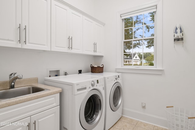 laundry area with sink, light tile patterned floors, cabinets, and independent washer and dryer