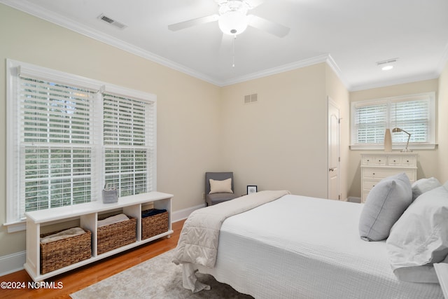 bedroom with ceiling fan, light hardwood / wood-style floors, and ornamental molding