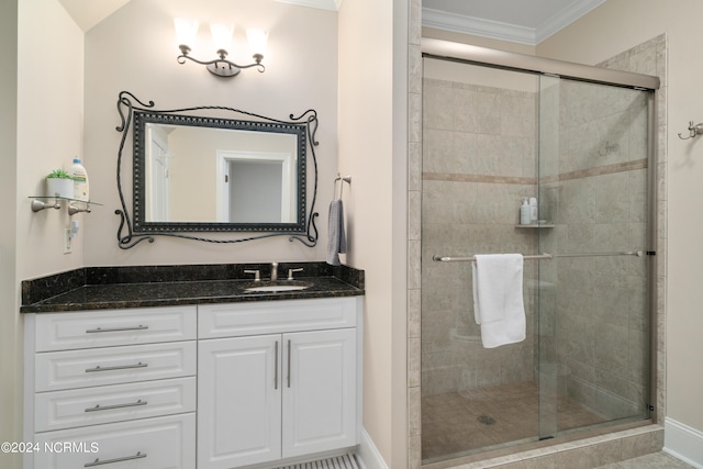 bathroom featuring vanity, a shower with shower door, and crown molding