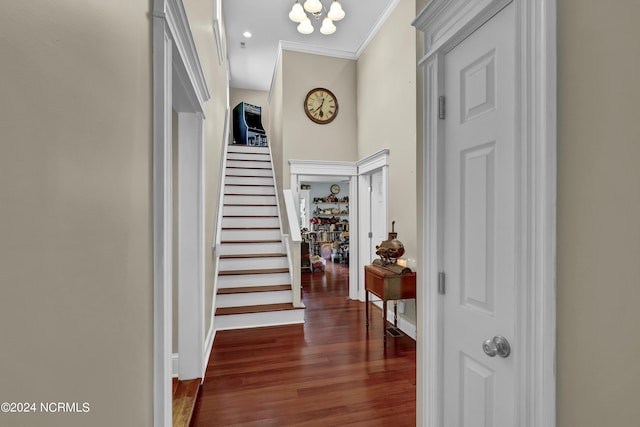 hallway featuring baseboards, a chandelier, stairway, crown molding, and wood finished floors