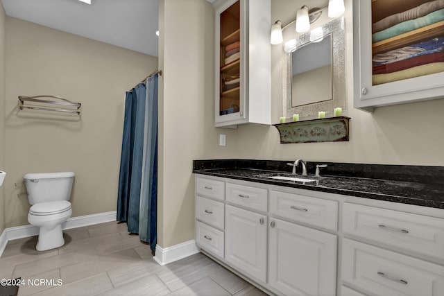 full bath featuring toilet, curtained shower, vanity, and baseboards