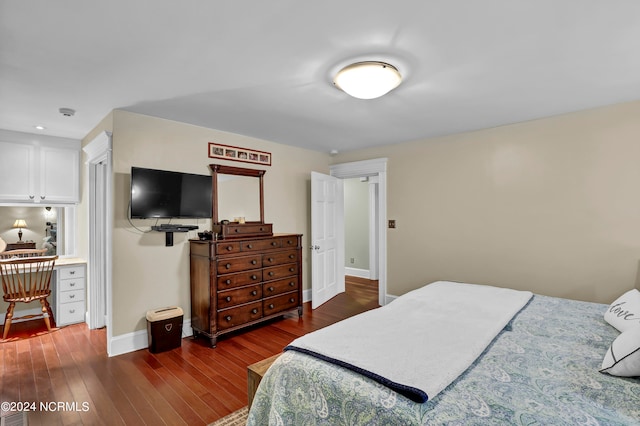 bedroom featuring built in desk and dark hardwood / wood-style floors