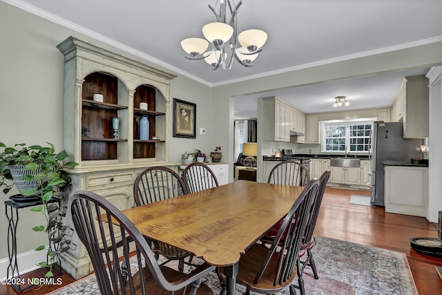 dining room with a chandelier, ornamental molding, and dark wood finished floors