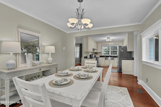 204 Van Riggs Rd, Hubert, NC 28539 - dining space with a chandelier, dark wood-style floors, and ornamental molding