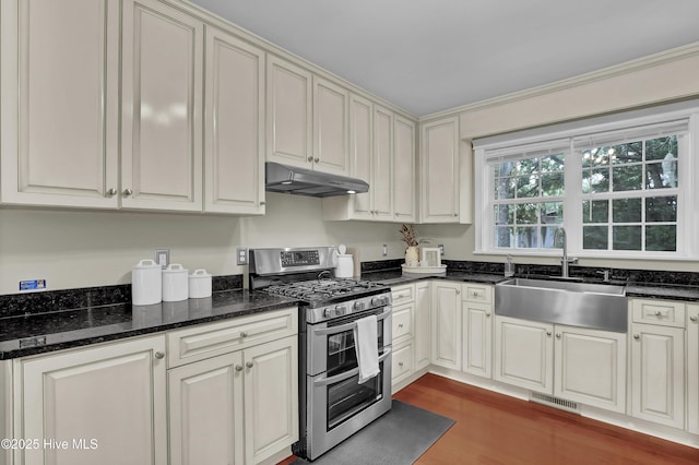 204 Van Riggs Rd, Hubert, NC 28539 - kitchen with range with two ovens, under cabinet range hood, wood finished floors, and dark stone counters