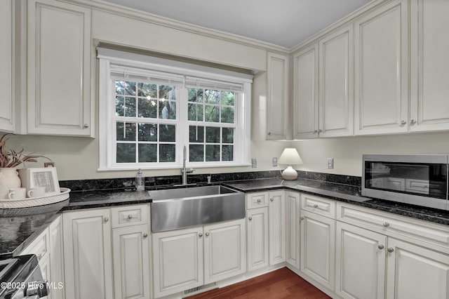 204 Van Riggs Rd, Hubert, NC 28539 - kitchen with stainless steel microwave, dark stone countertops, white cabinetry, and stove