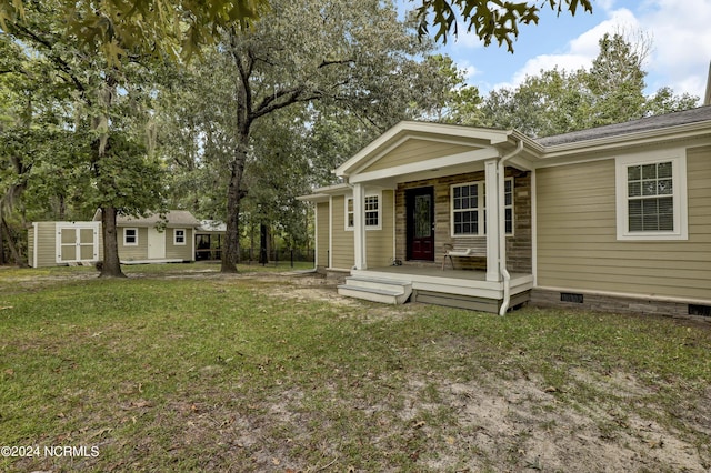 rear view of property with an outbuilding, fence, and a lawn
