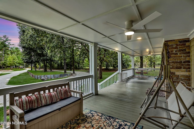 deck at dusk featuring ceiling fan and covered porch