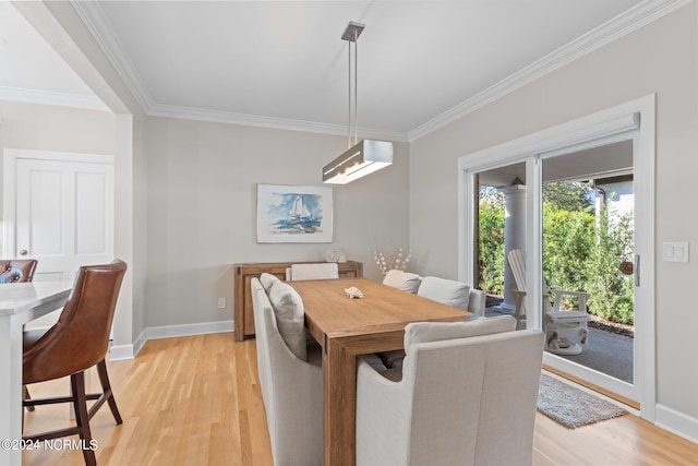 dining area with light hardwood / wood-style floors and ornamental molding