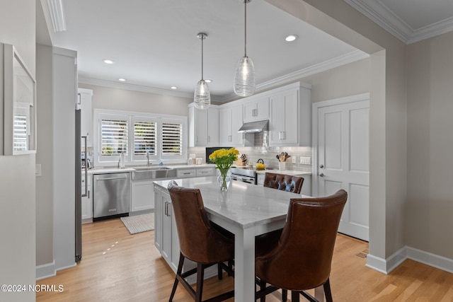 dining room featuring ornamental molding, light wood-type flooring, and sink