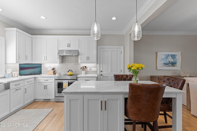 kitchen with exhaust hood, stainless steel electric stove, decorative light fixtures, and a breakfast bar