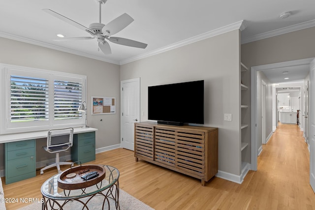 home office with ceiling fan, built in desk, crown molding, and light hardwood / wood-style floors