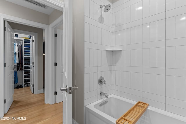 bathroom with wood-type flooring and tiled shower / bath combo