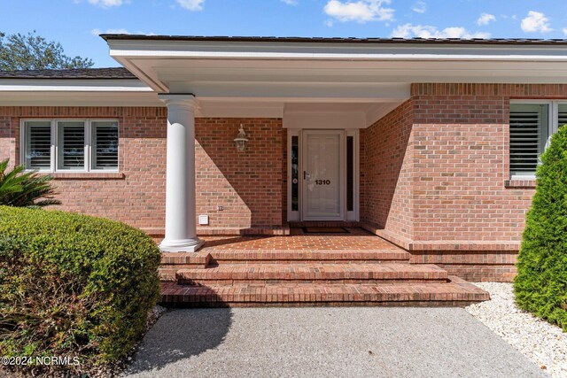 view of exterior entry featuring covered porch