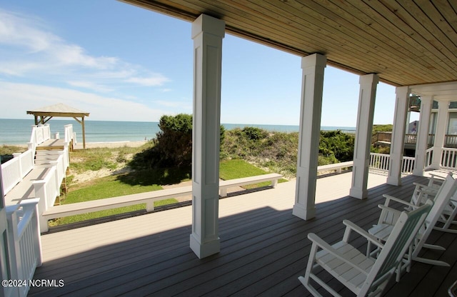 deck with a water view and a beach view