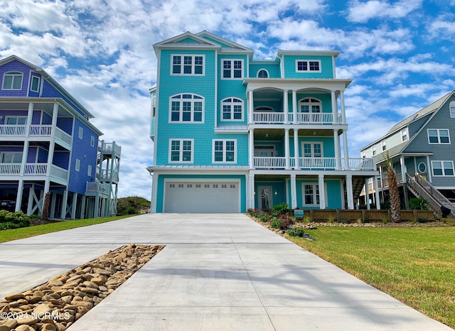 view of front facade featuring a garage, a balcony, and a front lawn