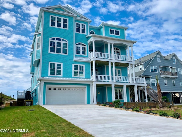 view of front of house with a front yard, a balcony, and a garage