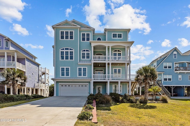 view of front of property featuring a front yard, a balcony, and a garage