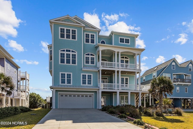 view of front of home with a front yard, a balcony, and a garage