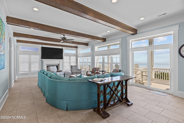 living room featuring ceiling fan, beam ceiling, light tile patterned floors, and a healthy amount of sunlight