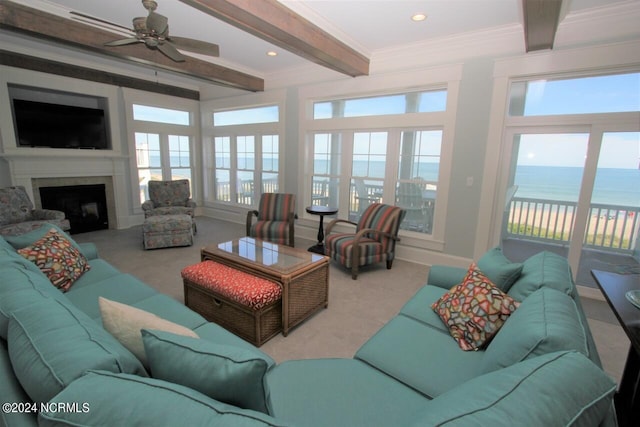 living room with ceiling fan, light carpet, a water view, and a healthy amount of sunlight