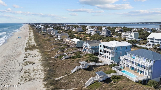 drone / aerial view with a water view and a beach view