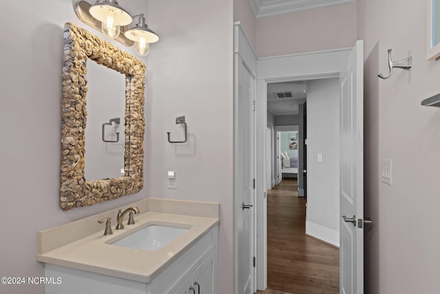 bathroom featuring vanity, ornamental molding, and hardwood / wood-style flooring