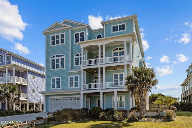 view of front facade featuring a garage, a balcony, and a front lawn