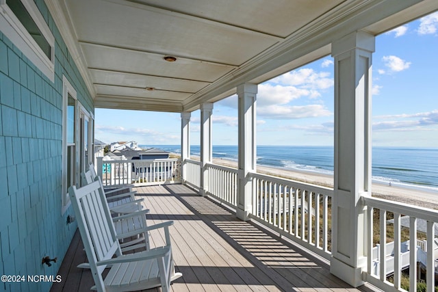 wooden terrace with a view of the beach and a water view