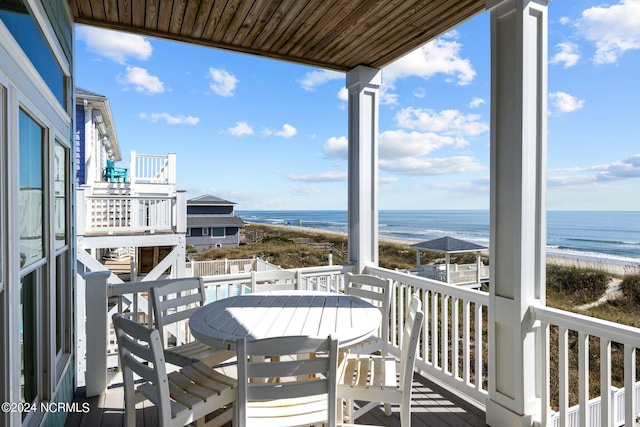 balcony featuring a view of the beach and a deck with water view