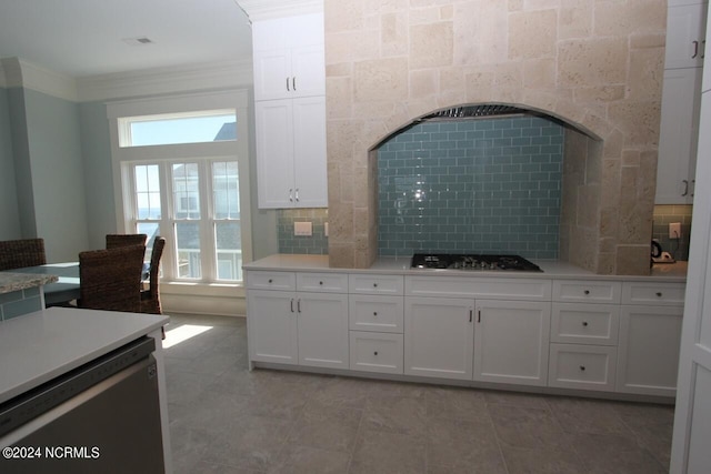 kitchen with white cabinets, stainless steel appliances, crown molding, and decorative backsplash