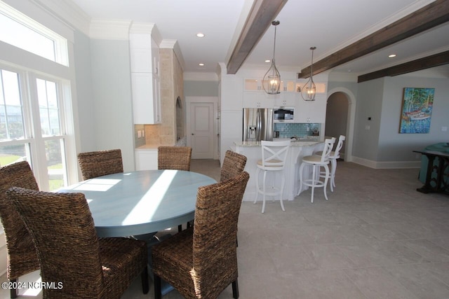 dining area with light tile patterned flooring, ornamental molding, beamed ceiling, and a chandelier