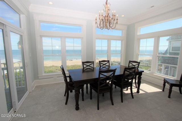 tiled dining area featuring a view of the beach, a water view, and a healthy amount of sunlight