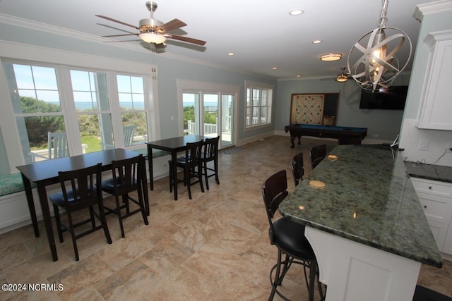 kitchen with pool table, ceiling fan, crown molding, a breakfast bar, and white cabinetry