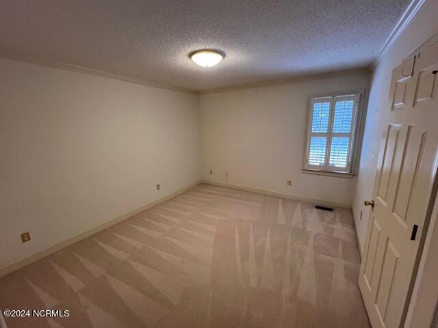 carpeted empty room featuring a textured ceiling and ornamental molding