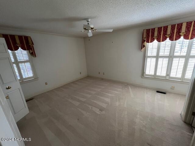 carpeted spare room with ceiling fan and a textured ceiling