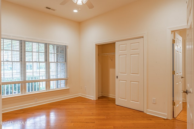 unfurnished bedroom with a closet, light hardwood / wood-style floors, and ceiling fan