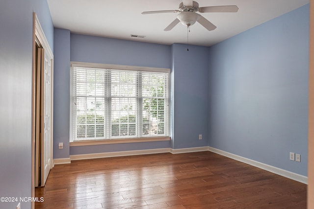 spare room with ceiling fan and dark wood-type flooring