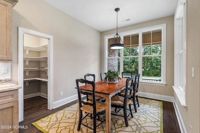 dining space featuring dark wood finished floors, visible vents, and baseboards