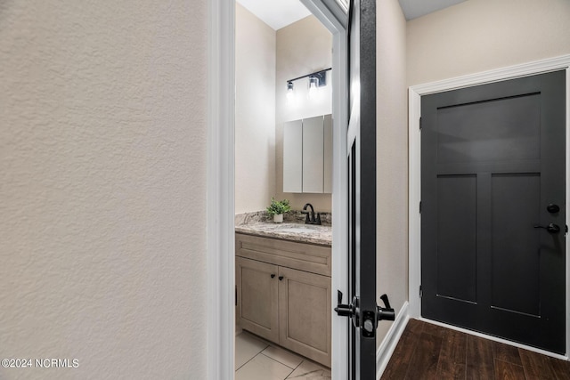 bathroom featuring a textured wall, wood finished floors, and vanity