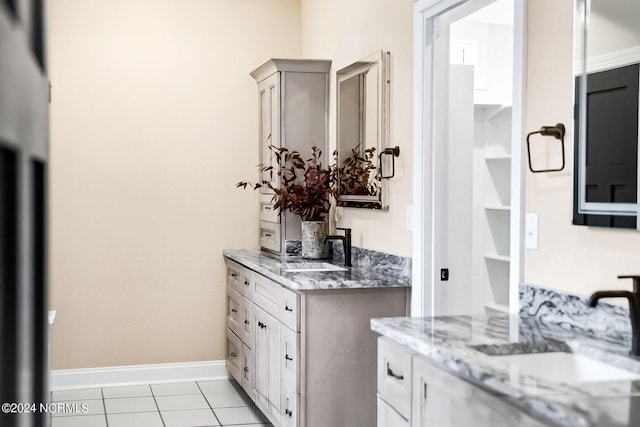 bar with a sink, baseboards, and light tile patterned floors