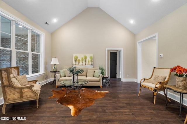 living room featuring high vaulted ceiling, visible vents, baseboards, and wood finished floors