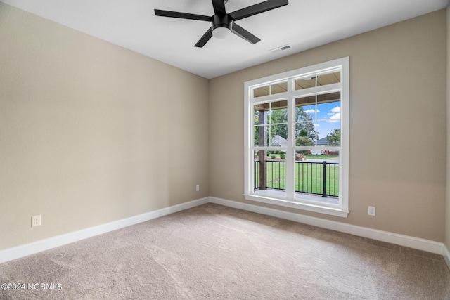 carpeted empty room with a ceiling fan, visible vents, and baseboards