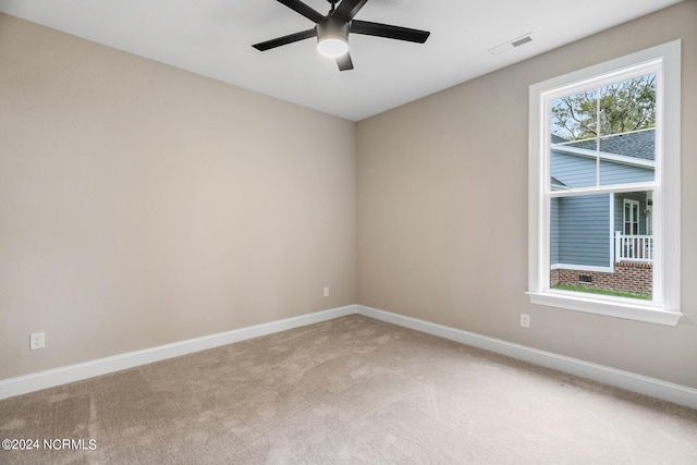 spare room featuring carpet floors, baseboards, visible vents, and ceiling fan