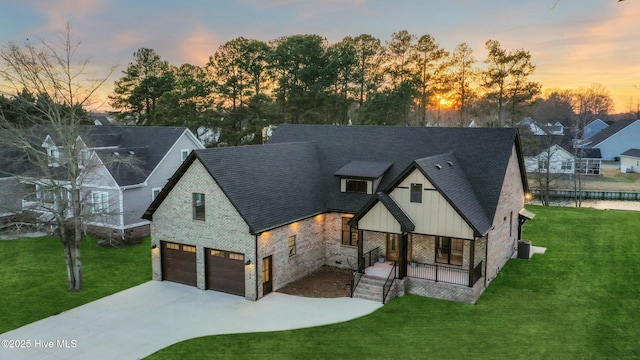 view of front facade featuring concrete driveway, an attached garage, a porch, board and batten siding, and a front yard